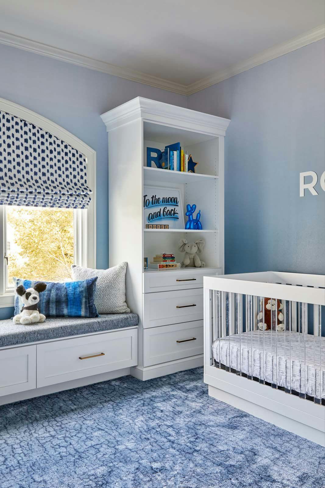 baby room with blue wall and floor and white cabinets and crib