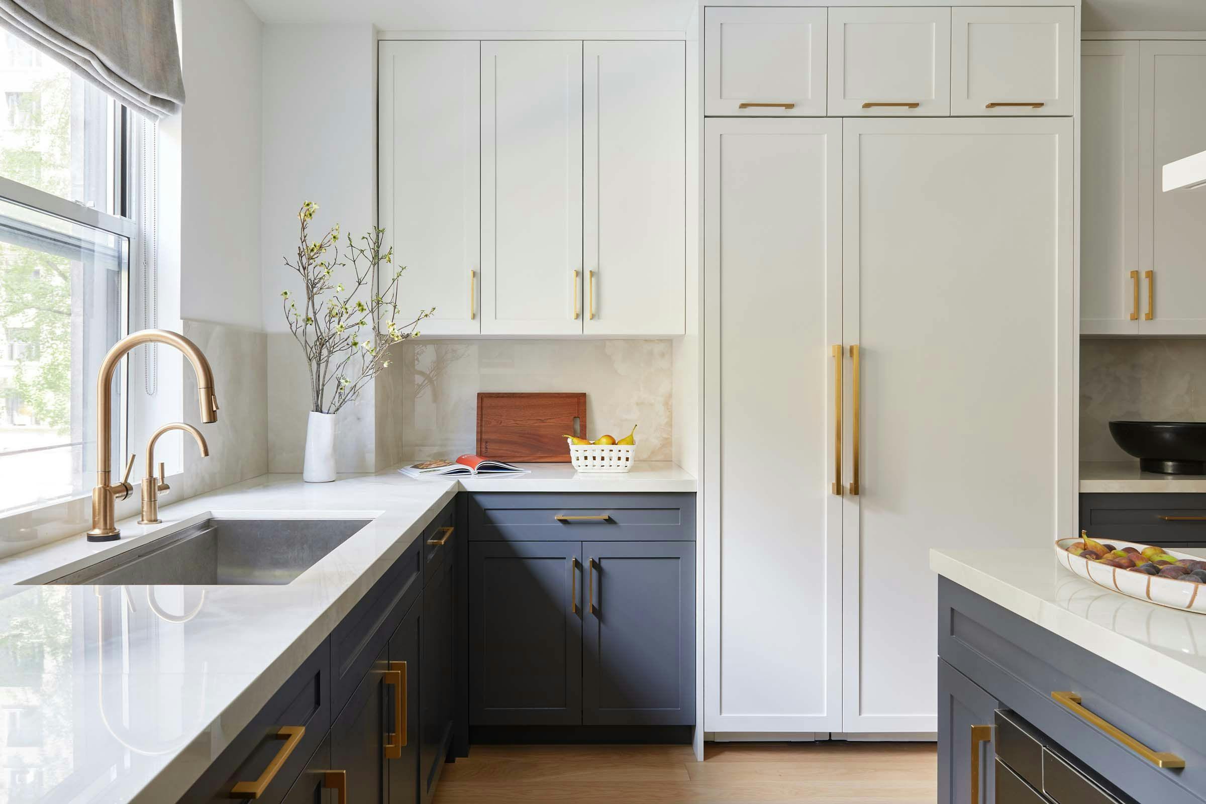 kitchen with white and grey cabinets with gold-colored accents