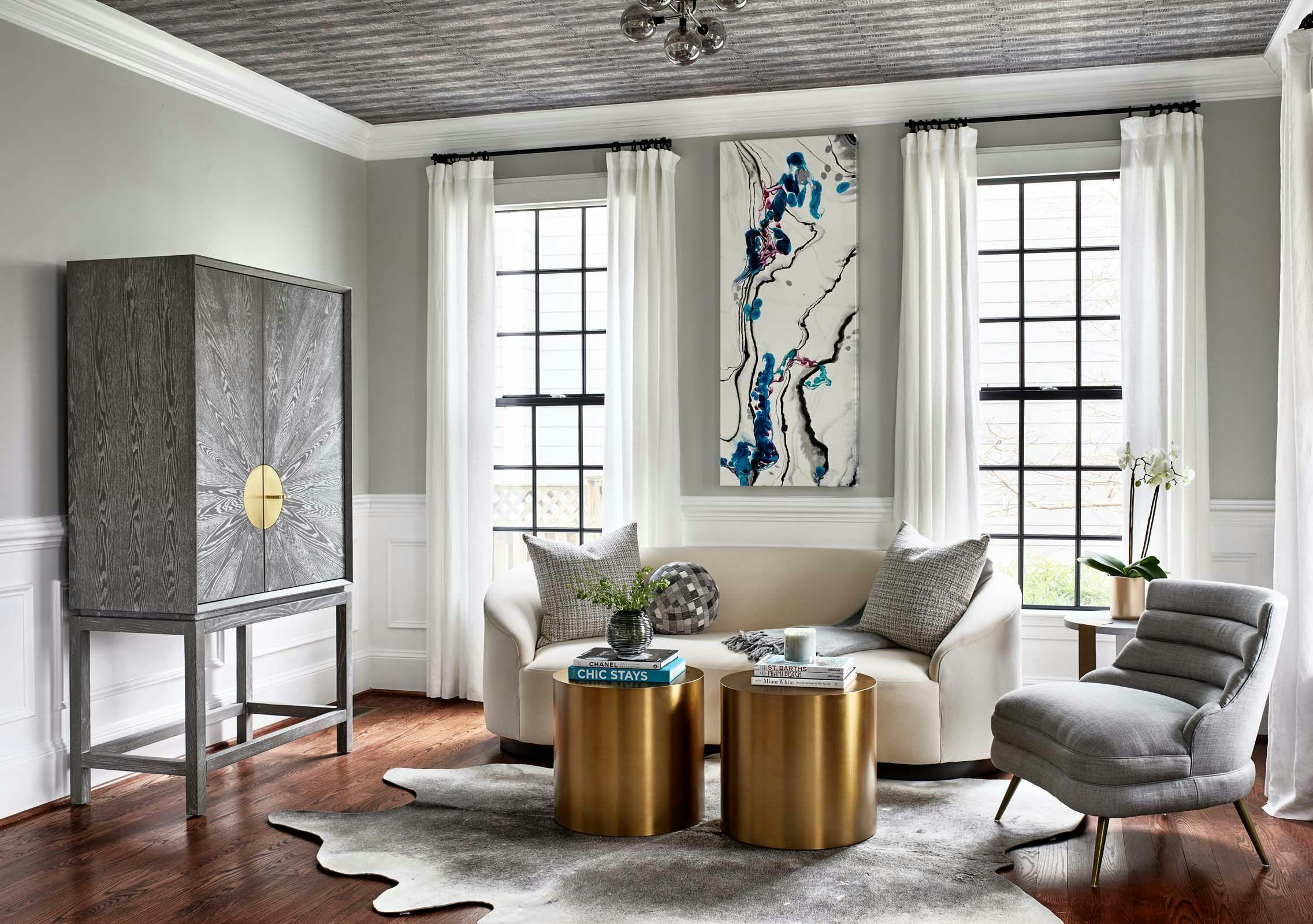 Living room with white and grey couches, grey chest, and copper-colored table