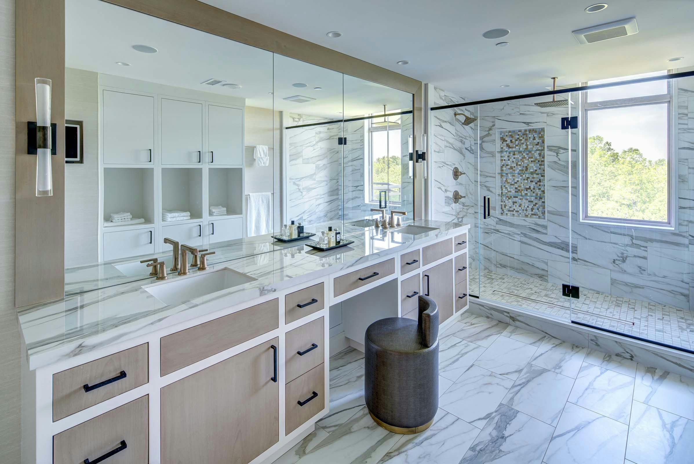 large bathroom with light wood color cabinets and walk-in shower, two sink vanity